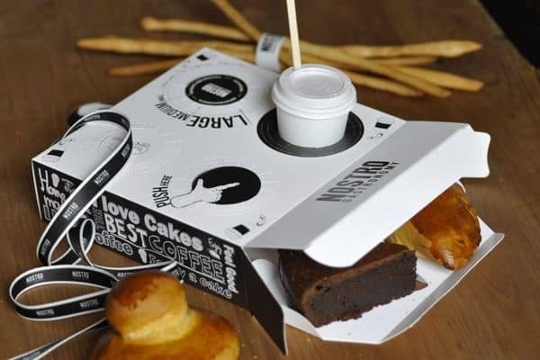 A pastry box with built-in coffee holder.