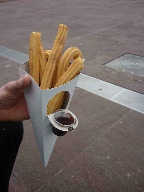 Churros with a dippable chocolate sauce container.