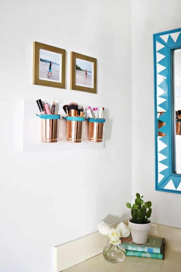For a tiny bathroom, combine wall decorations with storage by making pretty copper makeup cups.