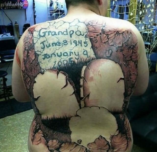 A memorial tattoo of gravestones which is badly down and covers the whole person’s back