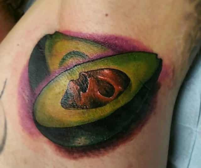 A millennial has had an open Avocado tattooed on themselves, complete with stone