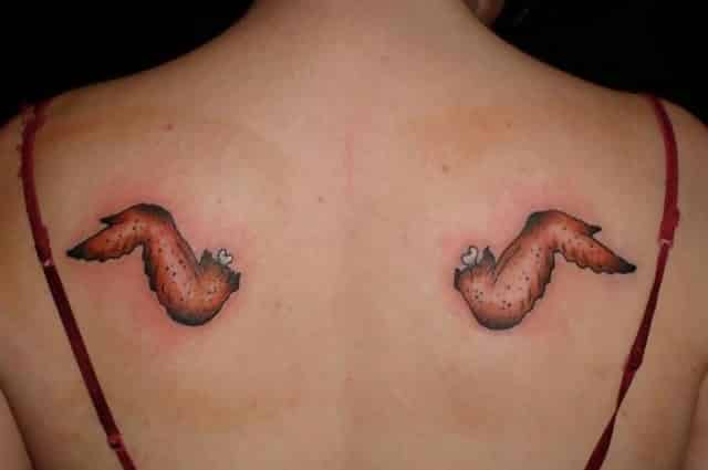 A woman with two tattoos of chicken wings on her back 