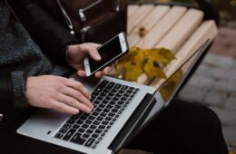Free Person in Black Jacket Using a Laptop Stock Photo